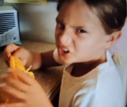 The spokesperson making an intense face while holding an orange